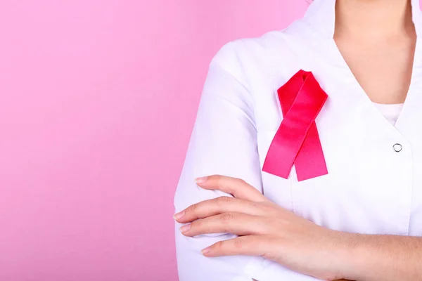 Läkare med band bildat aids symbol, närbild, färg bakgrunden — Stockfoto