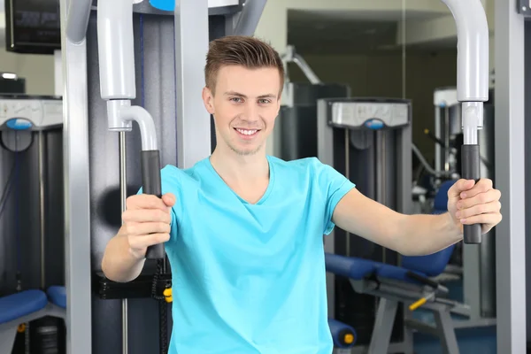 Młody człowiek trening z ciężarami w siłowni — Zdjęcie stockowe