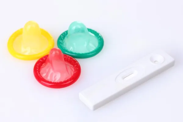 Condones de nacimiento y prueba de embarazo aislados en blanco — Foto de Stock