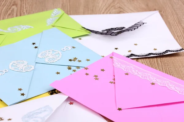 Bando de envelopes de cores e confetes close-up sobre fundo de madeira — Fotografia de Stock