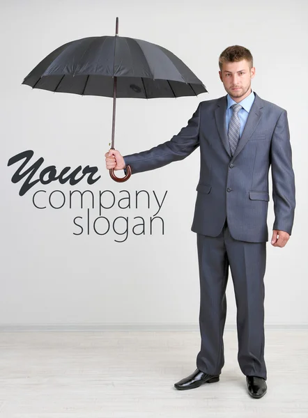 Biznesmen z parasolem. na szarym tle — Zdjęcie stockowe