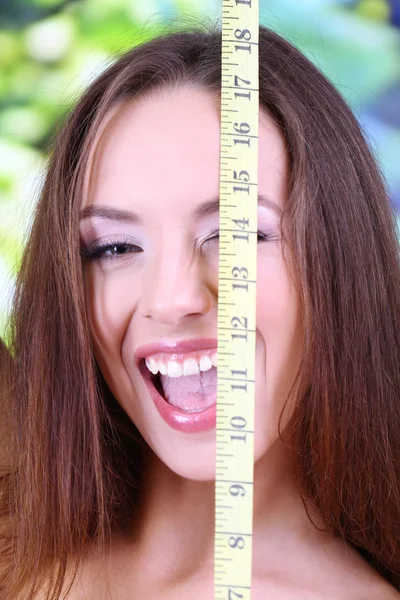 Beautiful young woman with measuring tape close up — Stock Photo, Image
