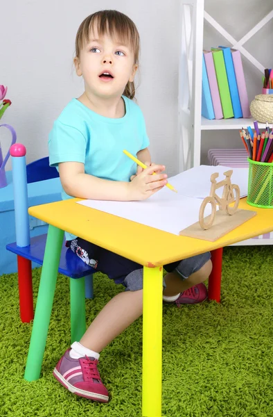 Menina desenha sentado à mesa no quarto — Fotografia de Stock