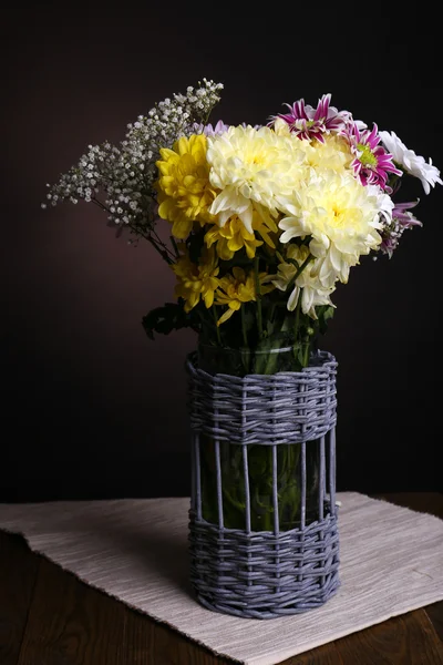 Beautiful chrysanthemum flowers in vase on table on brown background — Stock Photo, Image