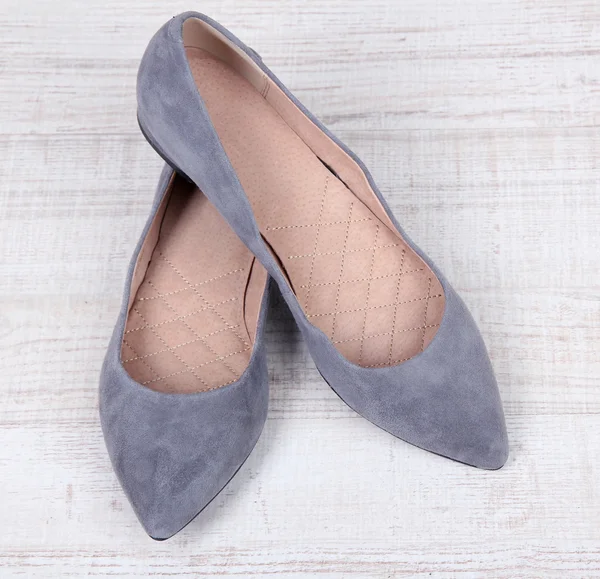 Beautiful grey female shoes on wooden background — Stock Photo, Image