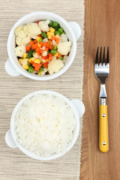 Gekookte rijst met groenten op houten tafel — Stockfoto