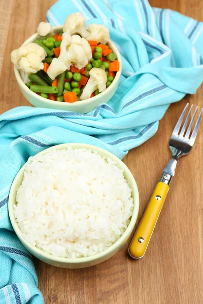 Gekookte rijst met groenten op houten tafel — Stockfoto