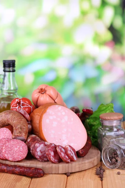 Different sausages on wooden table on natural background — Stock Photo, Image