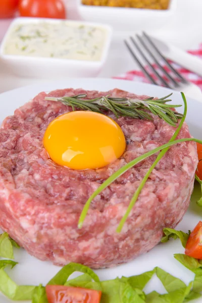 Delicioso bife tartare com gema de ovo na placa na mesa close-up — Fotografia de Stock