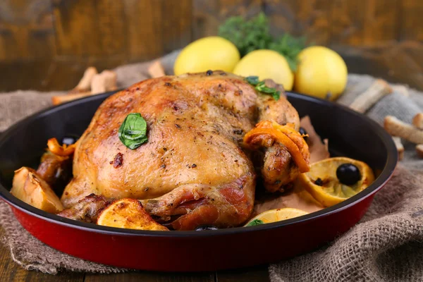 Pollo arrosto intero con verdure in padella, su fondo di legno — Foto Stock