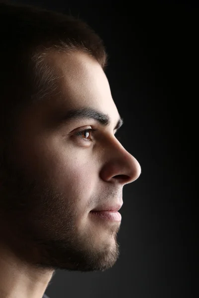 Schöner junger Mann auf dunklem Hintergrund — Stockfoto