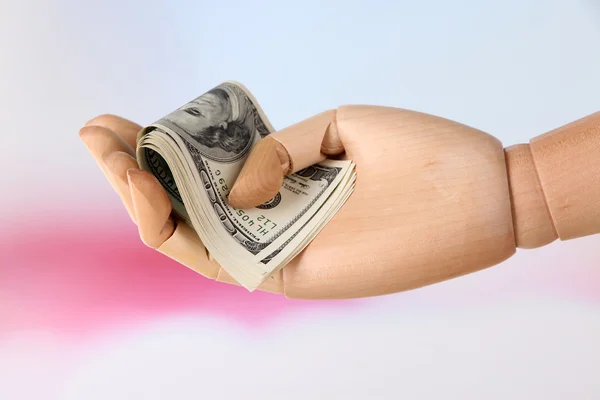 Pengar i trä hand, på ljus bakgrund — Stockfoto
