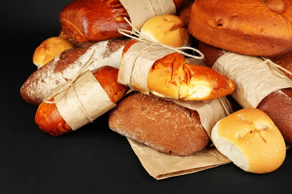 Diferentes tipos de pão no fundo preto, close-up — Fotografia de Stock