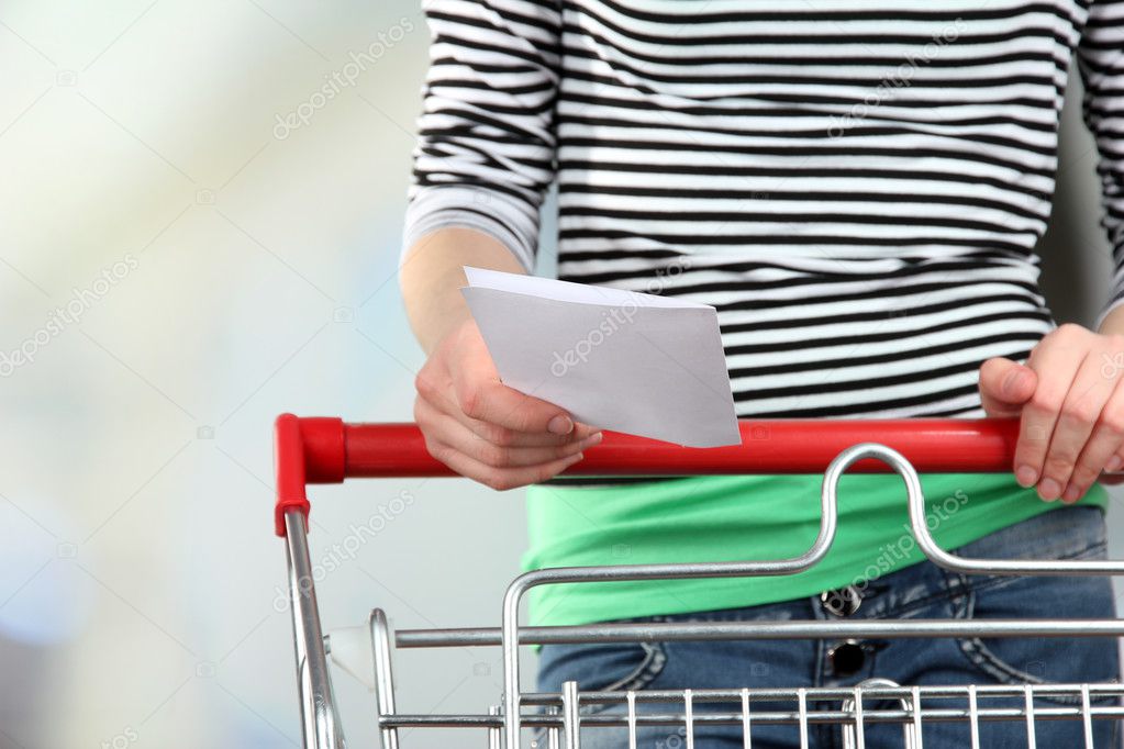 Woman with trolley in supermarket close-up