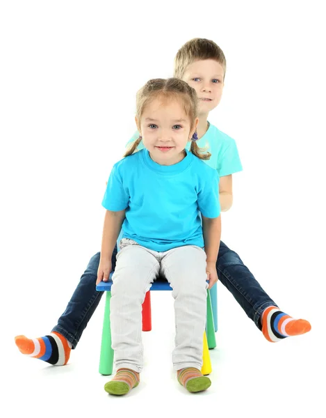 Kleine Kinder spielen auf Stühlen isoliert auf weiß — Stockfoto