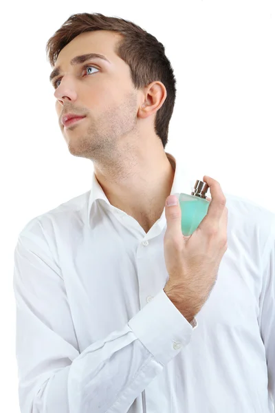 Bello giovane uomo utilizzando profumo isolato su bianco — Foto Stock