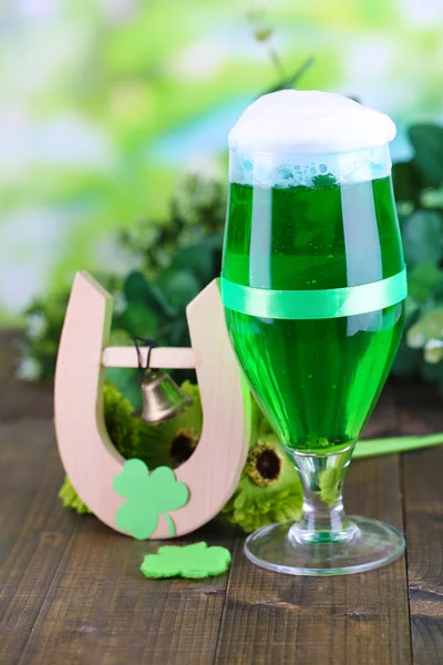 Copo de cerveja verde e ferradura para o dia de St Patricks em close-up de mesa de madeira — Fotografia de Stock