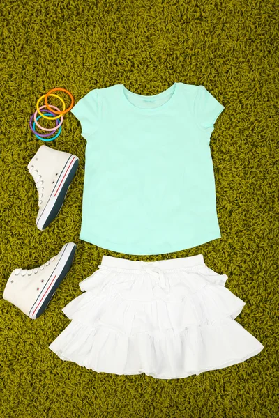 Hermosa ropa para niña en alfombra verde — Foto de Stock