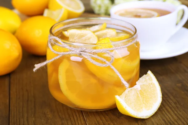 Tasty lemon jam with cup of tea on table close-up — Stock Photo, Image