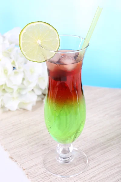 Glas Cocktail auf Tisch auf hellblauem Hintergrund — Stockfoto