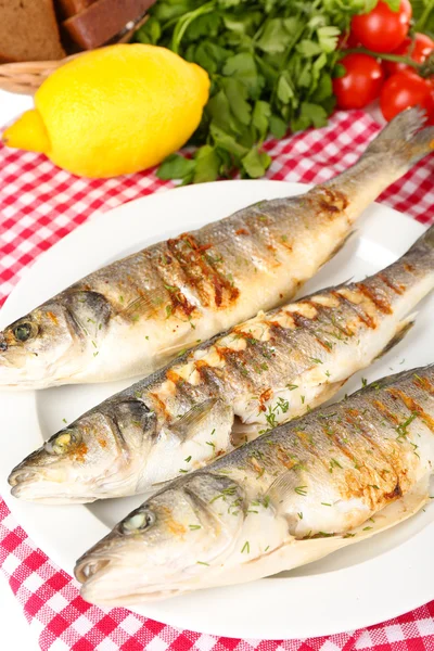 Ikan panggang lezat di piring di atas meja close-up — Stok Foto