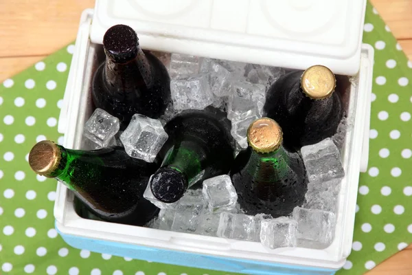 Jég mellkasi tele italok palackokban a színes szalvéta, fából készült háttér — Stock Fotó
