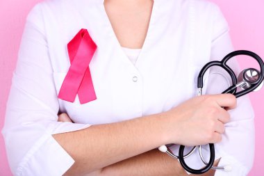 Doctor  with ribbon formed Aids symbol, close-up, on color background clipart