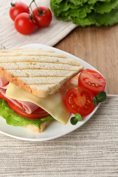 Sabroso sándwich con jamón sobre mesa de madera — Foto de Stock