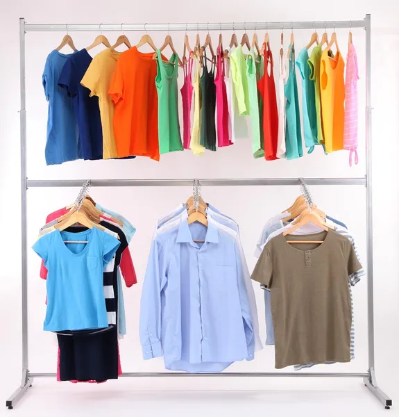 Different clothes on hangers, on gray background — Stock Photo, Image