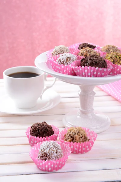 Набір шоколадних цукерок на столі на рожевому фоні — стокове фото