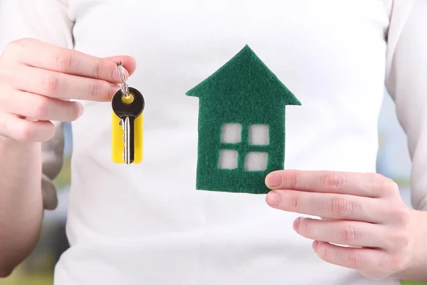 Little paper house in hand close-up, on bright background — Stock Photo, Image