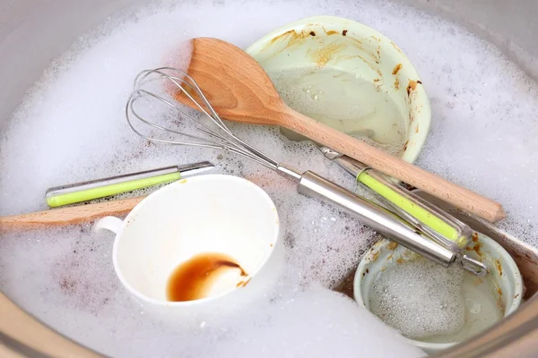 Utensils soaking in kitchen sink — Stock Photo, Image