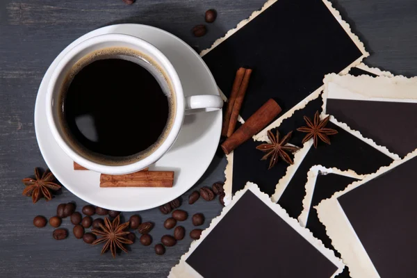 Koffiekopje en oude leeg foto's en specerijen, op houten achtergrond — Stockfoto