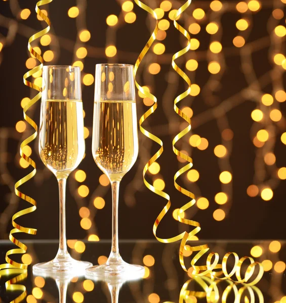 Glazen en een fles champagne op glanzende achtergrond — Stockfoto