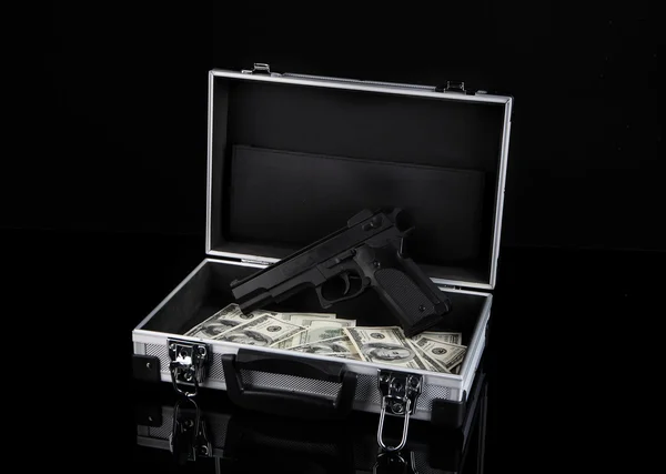 Estuche con dinero y pistola, aislado en negro —  Fotos de Stock