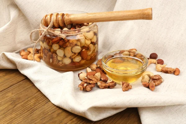 Zoete honing en verschillende noten op houten tafel — Stockfoto