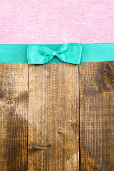 Tissu coloré avec ruban couleur et archet sur fond en bois — Stockfoto