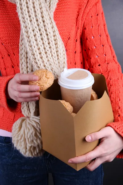 Kobieta trzyma box z kawa i ciasteczka na czarnym tle — Zdjęcie stockowe