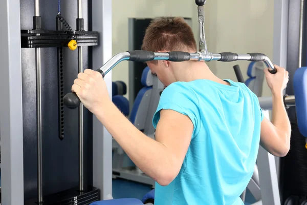 Młody człowiek trening z ciężarami w siłowni — Zdjęcie stockowe