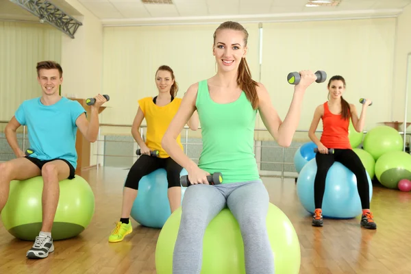 Genç güzel halklar topları ile spor salonunda nişanlı. — Stok fotoğraf