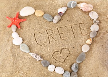 Inscription Crete in wet sand close-up background clipart