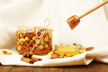 ahşap masa üzerinde farklı fındık ve tatlı bal