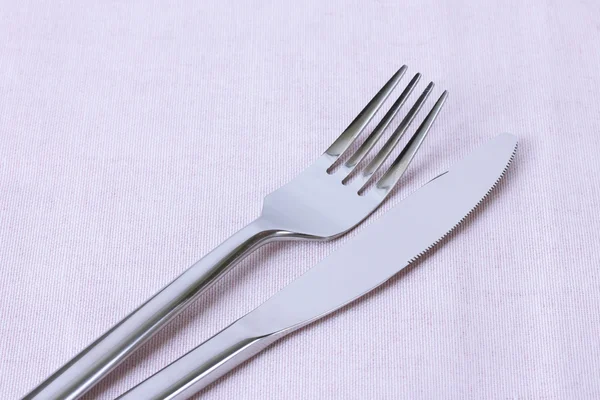 Fork and knife on pink  napkin close up — Stock Photo, Image