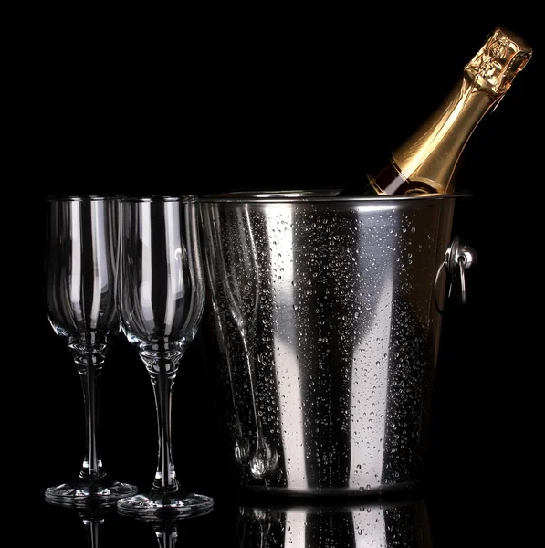 Bottle of champagne in bucket and goblets isolated on black — Stock Photo, Image