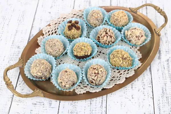 Set van chocolade snoepjes, op het dienblad, op een houten achtergrond kleur — Stockfoto