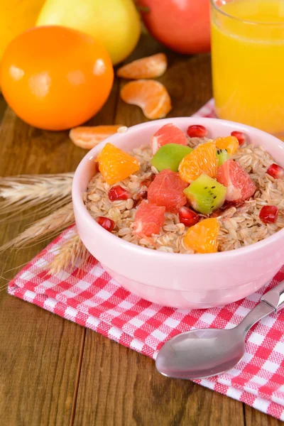 Delicious oatmeal with fruit in bowl on table close-up — Stock Photo, Image