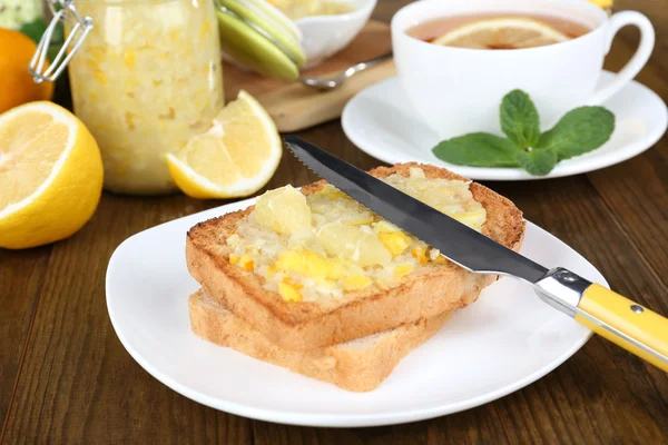 Delicious toasts with lemon jam on plate on table close-up — Stock Photo, Image