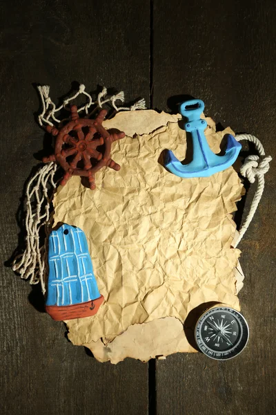 Old paper with sea accessories, isolated on wooden background — Stock Photo, Image