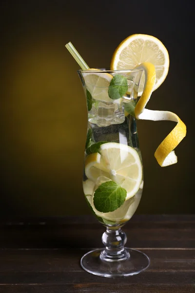 Verre de cocktail avec citron et menthe sur la table sur fond jaune foncé — Photo