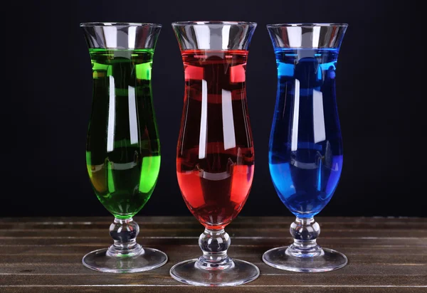 Glasses of cocktails on table on black background — Stock Photo, Image